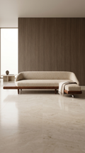 A luxurious Élan Curved Sectional sofa in premium Oatmeal bouclé upholstery featuring a low-slung, sculptural L-shape design with an integrated American Walnut side table and plinth base.